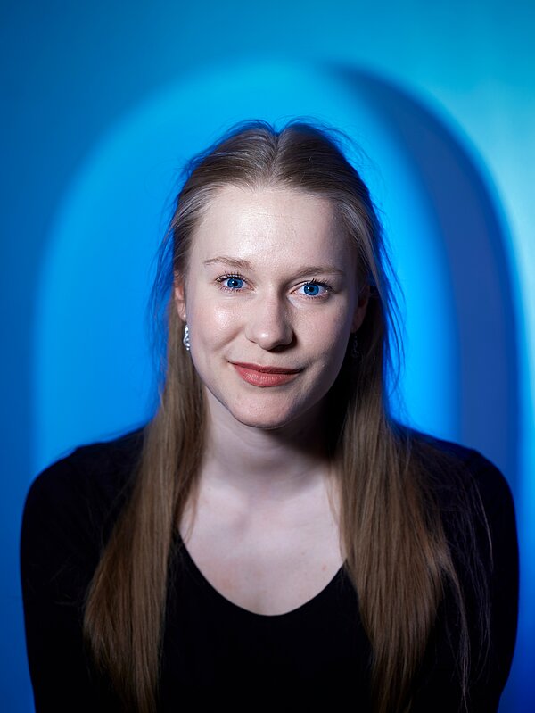 Clara Elisabeth Bauke vor blauem Hintergrund 