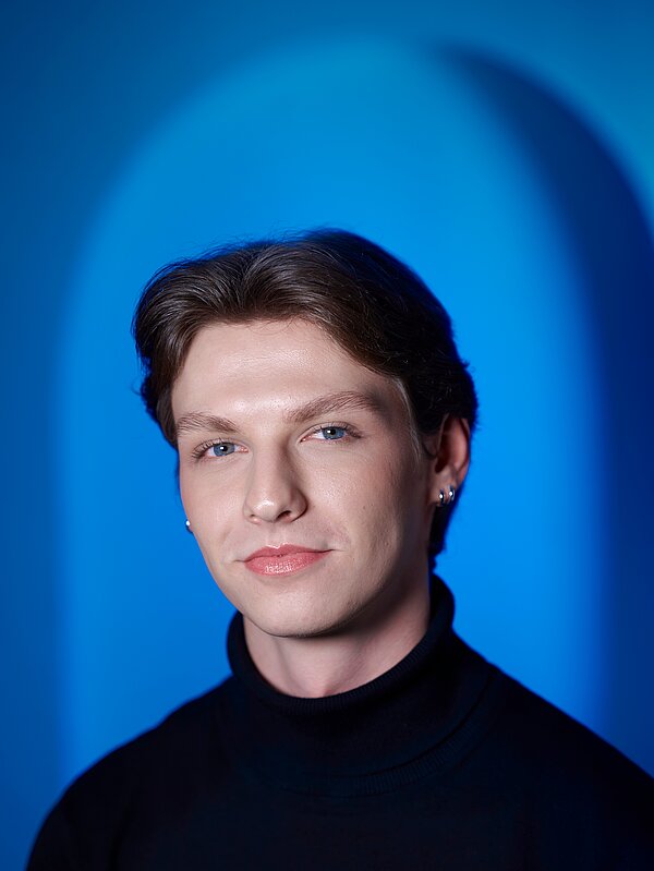 Max Voigt vor blauem Hintergrund